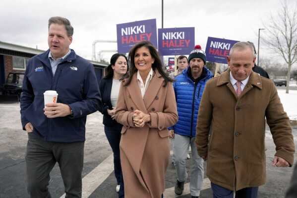 Republican presidential candidate former U.N. Ambassador Nikki Haley, center, walks with N.H. Gov. Chris Sununu, left, and retired U.S. Army Brig. Gen. Donald Bolduc, right, Tuesday, Jan. 23, 2024, before speaking with members of the media near a polling site at Winnacunnet High School in Hampton, N.H. (AP Photo/Steven Senne)