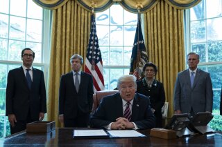 President Donald Trump speaks before signing a coronavirus aid package to direct funds to small businesses, hospitals, and testing, in the Oval Office of the White House, Friday, April 24, 2020, in Washington. From left, Treasury Secretary Steven Mnuchin, Sen. Roy Blunt, R-Mo., Trump, Small Business administrator Jovita Carranza, and House Minority Leader Kevin McCarthy of Calif. (AP Photo/Evan Vucci)