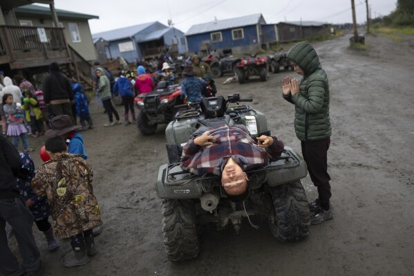 Jayden Charles gestures while resting on an ATV at the village carnival, Thursday, Aug. 17, 2023, in Akiachak, Alaska. The village hosted a multiday carnival with games and prizes for the village youth. (AP Photo/Tom Brenner)