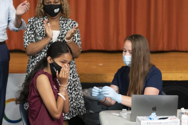 Ariel Quero, 16, left, a student at Lehman High School, reacts after getting the Pfizer COVID-19 vaccine from Katrina Taormina, right, July 27, 2021, in New York. The U.S. is expanding COVID-19 boosters, ruling that 16- and 17-year-olds can get a third dose of Pfizer’s vaccine. The U.S. and many other nations already were urging adults to get booster shots to pump up immunity that can wane months after vaccination, calls that intensified with the discovery of the worrisome new omicron variant. On Thursday, Dec. 9, 2021 the FDA gave emergency authorization for 16- and 17-year-olds to get a third dose of the vaccine made by Pfizer and its partner BioNTech -- if it’s been six months since their last shot. (AP Photo/Mark Lennihan, file)