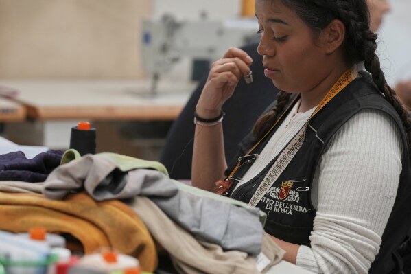 A tailor works on stage costumes in the "Teatro dell' Opera" opera house costumes laboratory, in Rome, Thursday, April 10, 2025. (AP Photo/Andrew Medichini)