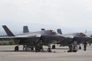FILE - U.S. military personnel work near F-35 fighter jet of the Vermont Air National Guard, parked in the military base at Skopje Airport, North Macedonia, on June 17, 2022. On Wednesday Jan. 4, 2023, The Czech Republic's government has approved legislation to make it mandatory for the country's defense spending to meet the required NATO goal of 2% of gross domestic product amid the Russian war against Ukraine. Among the planned biggest multi-billion dollars acquisitions of new arms, the Czechs have been negotiating with the United States a possible purchase of 24 F-35 fighter jets and with Sweden a plan to acquire 210 CV90 armored vehicles. (AP Photo/Boris Grdanoski, File)