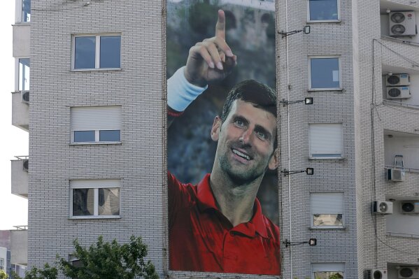 A billboard depicting Serbian tennis player Novak Djokovic and the Christian Orthodox monastery of Ostrog is seen on a building in Belgrade, Serbia, Wednesday, June 24, 2020. Djokovic has tested positive for the coronavirus after taking part in a tennis exhibition series he organized in Serbia and Croatia. The top-ranked Serb is the fourth player to test positive for the virus after first playing in Belgrade and then again last weekend in Zadar, Croatia.(AP Photo/Darko Vojinovic)