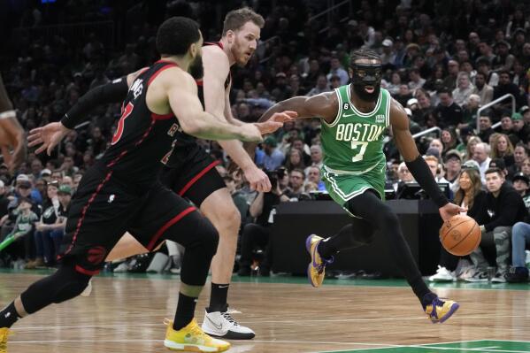 Boston Celtics guard Jaylen Brown (7) drives to the basket against Toronto Raptors guard Fred VanVleet (23) and center Jakob Poeltl, center, during the first half of an NBA basketball game Wednesday, April 5, 2023, in Boston. (AP Photo/Charles Krupa)