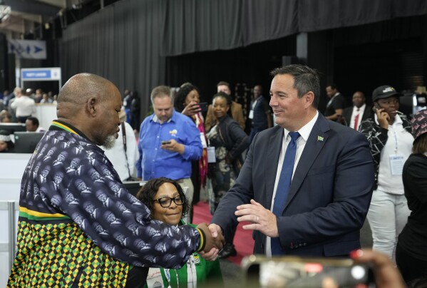 FILE - Leader of the main opposition Democratic Alliance John Steenhuisen, right, shakes hands with ANC's Chairman Gwede Mantashe, left, after elections on a visit to the Results Operation Centre (ROC) in Midrand, Johannesburg, South Africa, on May 31, 2024. (AP Photo/Themba Hadebe, File)