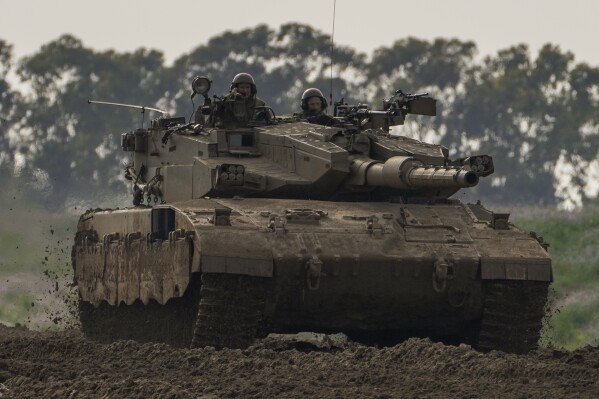 Israeli soldiers drive a tanks near the Gaza Strip border, in southern Israel, Monday, Feb. 19, 2024. (AP Photo/Tsafrir Abayov)