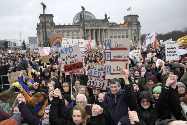 People hold hands in front of Germany's parliament Reichstag at a demonstration against the AfD party and right-wing extremism in Berlin, Germany, Saturday, Feb. 3, 2024 (AP Photo/Ebrahim Noroozi)
