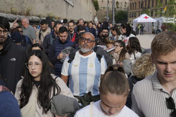 People wait in line to view Pope Francis lying in state inside St. Peter's Basilica, at the Vatican, Thursday, April 24, 2025. (AP Photo/Markus Schreiber)