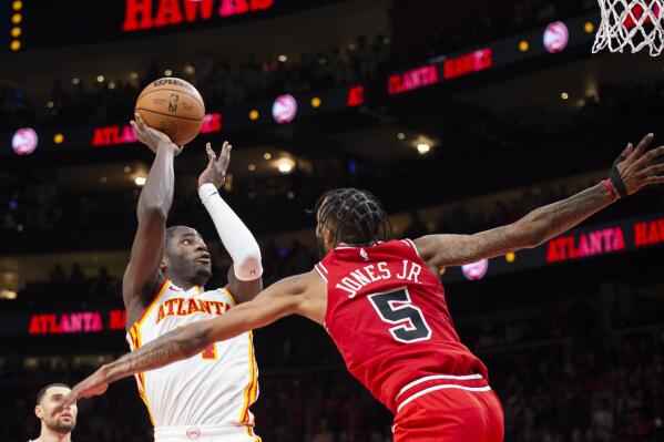 Atlanta Hawks forward AJ Griffin, front left, shoots a buzzer-beater over Chicago Bulls forward Derrick Jones Jr. during the second half of an NBA basketball game, Sunday, Dec. 11, 2022, in Atlanta. (AP Photo/Hakim Wright Sr.)