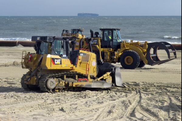 Heavy equipment moves around on the beach in Deal, N.J. on Wednesday, Jan. 19, 2022, where an ongoing beach replenishment project suffered erosion from a weekend storm. Federal and state officials are trying to determine whether additional sand needs to be pumped ashore to replace what washed away. (AP Photo/Wayne Parry)