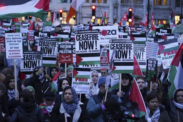 People take part in a Palestine Solidarity Campaign rally outside the Houses of Parliament as MPs debate calls for a ceasefire in Gaza, in London, Wednesday Feb. 21, 2024. (Lucy North/PA via AP)