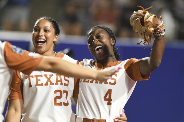 Texas infielder Viviana Martinez (23) and outfielder Adayah Wallace (4) celebrate after beating Texas Tech during the first game of the NCAA softball Women's College World Series finals in Oklahoma City, Wednesday, June 4, 2025. (AP Photo/Kyle Phillips)