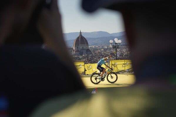 Britain's Mark Cavendish greets spectators during the team presentation in Florence, Italy, Thursday, June 27, 2024, two days before the start of the Tour de France cycling race. (AP Photo/Jerome Delay)