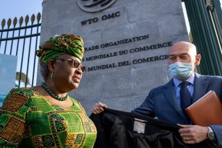 FILE - In this Monday, March 1, 2021 file photo, New Director-General of the World Trade Organisation Ngozi Okonjo-Iweala, left, walks at the entrance of the WTO, following a photo-op upon her arrival at the WTO headquarters to take office in Geneva, Switzerland. The World Trade Organization is raising its estimate for the rebound in global trade in goods but warning that the COVID-19 pandemic still poses the greatest threat to a recovery that is being hampered by lagging vaccinations, regional disparities and weakness in services. The organizations' WTO Director-General Ngozi Okonjo-Iweala called for a better access to vaccines for people in in poorer countries. (Fabrice Coffrini/Pool/Keystone via AP, FIle)