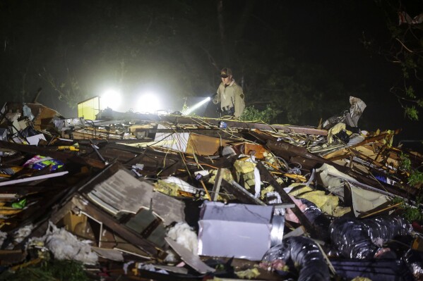 An Oklahoma State Highway Patrol trooper searches for storm damage on Tuesday, May 7, 2024, in Barnsdall, Oklahoma.  (Mike Simons/Tulsa World via AP)