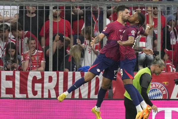 Leipzig's Dominik Szoboszlai, left, celebrates with Leipzig's Christopher Nkunku after scoring his side's third goal during the German Bundesliga soccer match between FC Bayern Munich and RB Leipzig at the Allianz Arena stadium in Munich, Germany, Saturday, May 20, 2023. (AP Photo/Matthias Schrader)