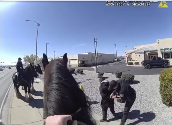 This photo taken from Albuquerque Police Department police video shows police making an arrest on March 20, 2024 after a chase with a horse-mounted police officer in Albuquerque, N.M. The shoplifter was detained outside a Walgreens. (Albuquerque Police Department via AP)