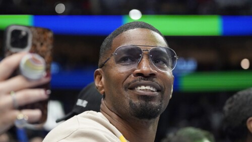 FILE - Jamie Foxx smiles during an NBA basketball game between the Washington Wizards and Dallas Mavericks in Dallas, Saturday, Nov. 27, 2021. Academy Award winning actor, Grammy winning singer and comedian says he “went to hell and back” but is recovering from an undisclosed medical condition. Foxx made his first public comments in an Instagram message posted on Friday, July 21, 2023 after being hospitalized in April. (AP Photo/LM Otero, File)