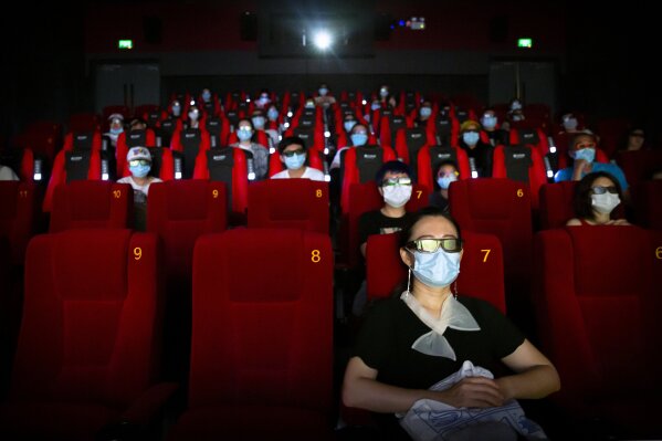 People wearing face masks to protect against the coronavirus sit spaced apart as they watch the film "Dolittle" at a movie theater in Beijing, Friday, July 24, 2020. Beijing partially reopened movie theaters Friday as the threat from the coronavirus continues to recede in China’s capital. (AP Photo/Mark Schiefelbein)