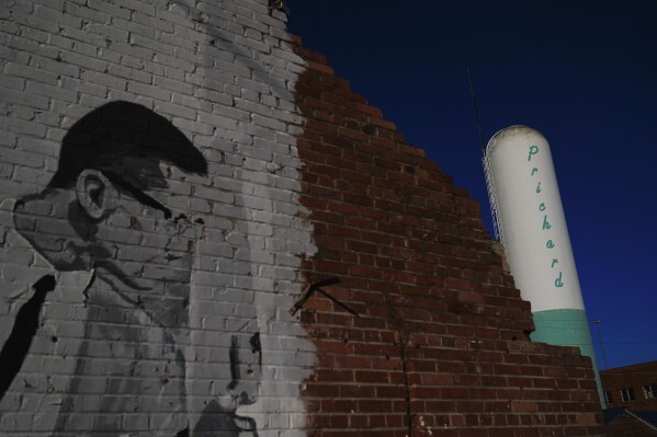 A Prichard water tower stands near downtown Prichard, Ala., on Wednesday, Dec. 6, 2023. The economically stressed city loses about 60% of its drinking water through leaks in its decrepit distribution system. Communities nationwide lose trillions of gallons. (AP Photo/Brynn Anderson)