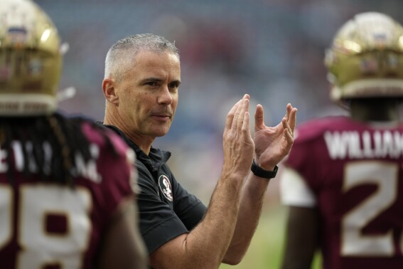 Florida State head coach Mike Norvell claps as his players warm up for the Orange Bowl NCAA college football game against Georgia, Saturday, Dec. 30, 2023, in Miami Gardens, Fla. (AP Photo/Rebecca Blackwell)