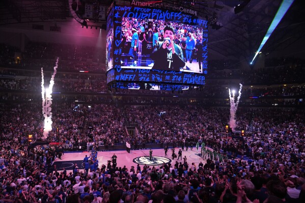 Boston Celtics and Dallas Mavericks players stands with fans for the national anthem before Game 4 of the NBA basketball finals, Friday, June 14, 2024, in Dallas. (AP Photo/Julio Cortez)