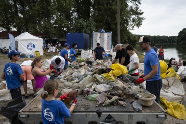 Volunteers selectively sort the collected rubbish after they arrived to the campsite for that day on Tuesday, Aug. 1, 2023. (AP Photo/Denes Erdos)