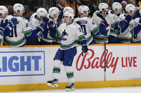 Vancouver Canucks left wing Nils Hoglander (21) celebrates a goal with teammates during the second period of an NHL hockey game against the Nashville Predators, Tuesday, Dec. 19, 2023, in Nashville, Tenn. (AP Photo/George Walker IV)