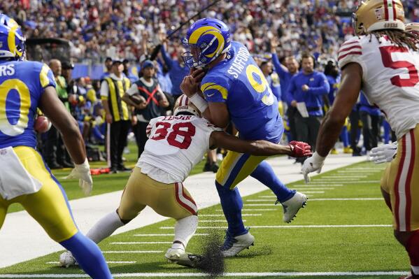 Los Angeles Rams quarterback Matthew Stafford (9) gets in for a touchdown as San Francisco 49ers cornerback Deommodore Lenoir attempts a tackle during the first half of an NFL football game Sunday, Oct. 30, 2022, in Inglewood, Calif. (AP Photo/Gregory Bull)