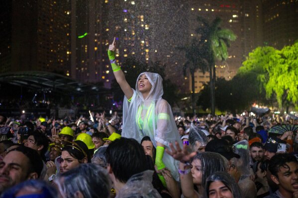 A woman reacts to music as it rains during the Ultra music festival at Bayfront Park in downtown Miami on Friday, March 22, 2024. (D.A. Varela/Miami Herald via AP)