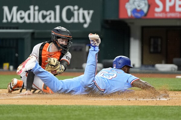 Texas Rangers' Adolis Garcia slides steals home ahead of the attempted tag by San Francisco Giants catcher Patrick Bailey in the first inning of a baseball game, Sunday, June 9, 2024, in Arlington, Texas. Wyatt Langford stole second on the same play. (AP Photo/Tony Gutierrez)