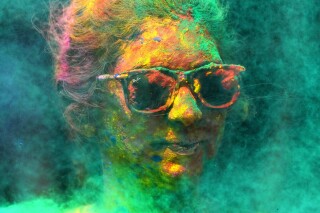 FILE - A woman smeared with colors celebrates Holi, the Hindu festival of colors, in Mumbai, India, Tuesday, March 7, 2023. (AP Photo/Rajanish Kakade, File)