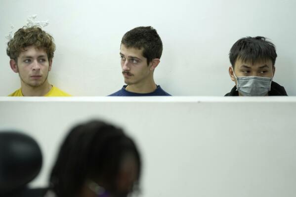 Belgian nationals Lornoy David, left, Seppe Lodewijckx, center and Vietnamese national Duh Hung Nguyen appear at the Jomo Kenyatta International Airport Law Courts in Nairobi, Kenya Wednesday, April 23, 2025. (AP Photo/Brian Inganga)