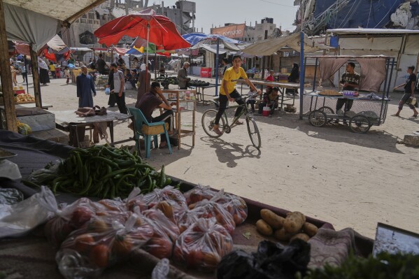 Palestinians purchase goods at a makeshift market in Khan Younis, Gaza Strip, Sunday, May 11, 2025. (AP Photo/Abdel Kareem Hana)