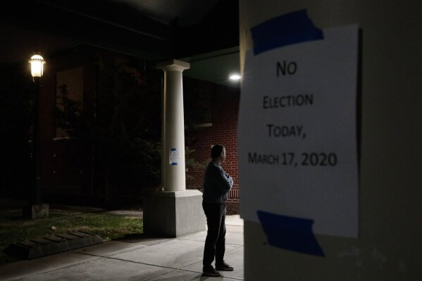 FILE - In this March 17, 2020, file photo a man, who hoped to vote in the scheduled primary election, stands outside a closed polling station at Schiller Recreation Center in Columbus, Ohio. U.S. elections have been upended by the coronavirus pandemic. At least 13 states have postponed voting and more delays are possible as health officials warn that social distancing and other measures to contain the virus might be in place for weeks, if not months. (Joshua A. Bickel/The Columbus Dispatch via AP, File)