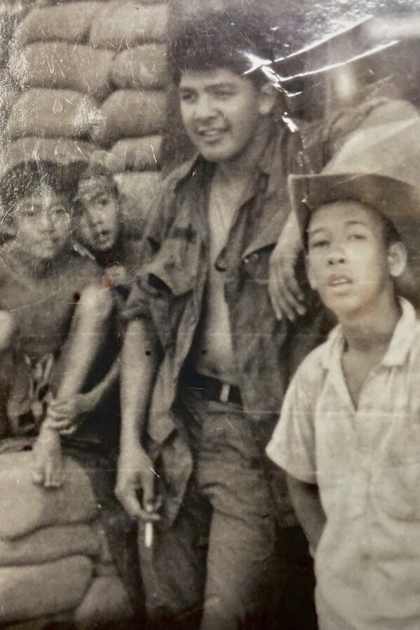 This photo provided by George Bennett shows Bennett with children from the Dau Tieng village during his service in Vietnam from 1966 to 1967. (George Bennett via AP)