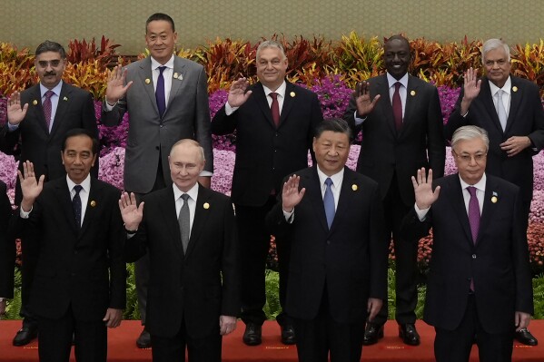 FILE- From left in front row, Indonesian President Joko Widodo, Russian President Vladimir Putin, Chinese President Xi Jinping, Kazakhstan President Kassym-Jomart Tokayev and Hungarian Prime Minister Viktor Orban, back centre, with other leaders wave during a group photo session at the Belt and Road Forum in Beijing Wednesday, Oct. 18, 2023. (Suo Takekuma/Pool Photo via AP, File)