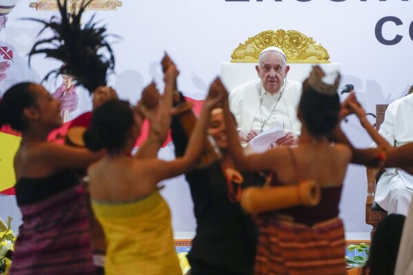 Pope Francis looks at traditional dancers as he arrives at the Centro de Convenções in Díli, East Timor, Sept. 11, 2024, for a meeting with young people. (AP Photo/Gregorio Borgia)