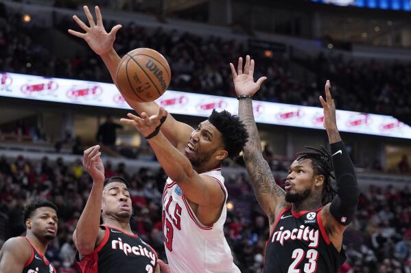 Chicago Bulls center Tony Bradley, center, rebounds a ball against Portland Trail Blazers forward Trendon Watford, front left, and guard Ben McLemore (23) during the second half of an NBA basketball game in Chicago, Sunday, Jan. 30, 2022. (AP Photo/Nam Y. Huh)