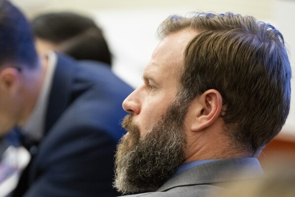 FILE - Defendant Matthew Collins looks on as his attorney Jared Ausserer gives closing arguments during the trial of three police officers in the killing of Manny Ellis at Pierce County Superior Court, Dec. 13, 2023, in Tacoma, Wash. Three Washington state police officers who were cleared of all criminal charges last month in the 2020 death of Ellis will each receive $500,000 to leave the Tacoma Police Department, according to documents released, Tuesday, Jan. 16, 2024. (Brian Hayes/The News Tribune via AP, Pool, File)