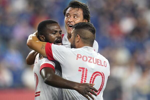 Toronto FC defender Kemar Lawrence, left, is congratulated by midfielder Alejandro Pozuelo (10) after his goal in the first half of an MLS soccer match against the New England Revolution, Wednesday, July 7, 2021, in Foxborough, Mass. At rear is Toronto FC forward Tsubasa Endoh. (AP Photo/Charles Krupa)