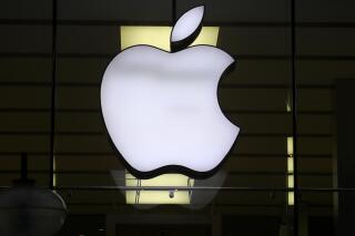 FILE - In this Wednesday, Dec. 16, 2020 file photo, the logo of Apple is illuminated at a store in the city center in Munich, Germany. Apple said Friday, Sept. 3, 2021 it's delaying its plan to scan U.S. iPhones for images of child sexual abuse, saying it needs more time to refine the system before releasing it. The company had revealed last month that it was working on a tool to detect known images of child sexual abuse, which would work by scanning files before they're uploaded to iCloud. (AP Photo/Matthias Schrader, file)