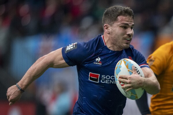 France's Antoine Dupont runs the ball to score a try against Australia during a Vancouver Sevens rugby game in Vancouver, British Columbia, Saturday, Feb. 24, 2024. (Ethan Cairns/The Canadian Press via AP)