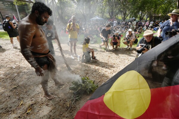 Neenan Simpson tends a smoldering fire that will be used for a smoking ceremony at an Indigenous Australians protest during Australia Day in Sydney, Friday, Jan. 26, 2024. Thousands of Australians protest on the anniversary of British colonization of their country amid fierce debate over whether the increasingly polarizing national holiday dubbed 