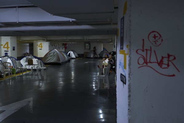 People spend the night in an underground parking garage as a precaution against possible Iranian missile attacks, in Tel Aviv, Israel, Monday, June 23, 2025. (AP Photo/Oded Balilty)