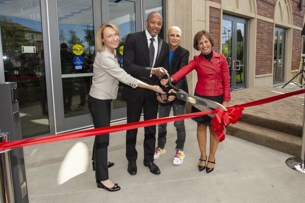 Dean Erica Muhl, from left, recording artist Andre "Dr Dre" Young, record producer Jimmy Iovine, and President Carol L. Folt, cut the ribbon at the official opening and dedication of Iovine and Young Hall at the University of Southern California campus in Los Angeles, Wednesday, Oct 2, 2019. The building was named after Iovine and Dr. Dre who donated a combined $70 million in 2013 to create the Jimmy Iovine and Andre Young Academy for Innovation.  (Gus Ruelas/University of Southern California via AP)