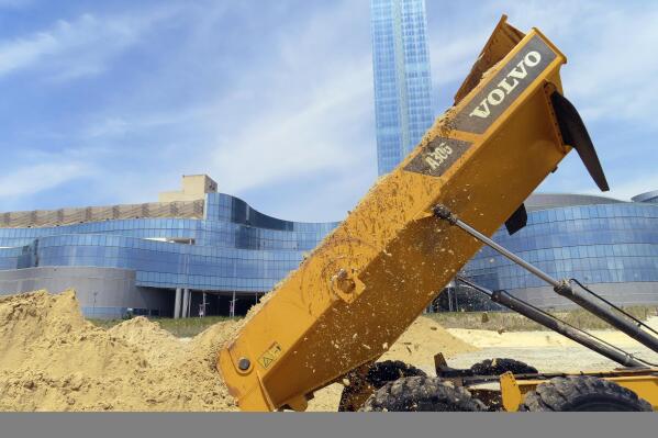 A load of sand is dumped on the beach in front of the Ocean Casino Resort in Atlantic City, N.J., Friday, May 12, 2023. The casino is spending up to $700,000 of its own money to rebuild the eroded beach, deciding it cannot wait another year or two for the next government-funded beach widening project scheduled for the area. (AP Photo/Wayne Parry)