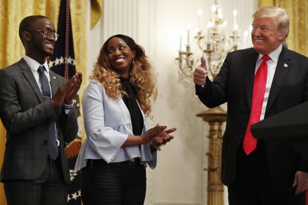 
              President Donald Trump, right, makes the thumbs up sign toward Cam'eron Hill, left, and his mother LaSonya Hill, of Jacksonville, Fla., during an event about taxes, Friday, June 29, 2018, in the East Room of the White House in Washington. (AP Photo/Jacquelyn Martin)
            