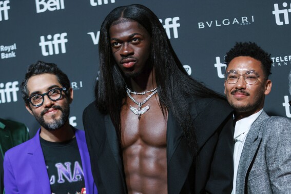 Directors Carlos Lopez Estrada, left, and Zac Manuel, right stand with Lil Nas X as they arrive on the red carpet ahead of the premiere of "Lil Nas X: Long Live Montero" at the Toronto International Film Festival on Saturday, Sept. 9, 2023, in Toronto. (Cole Burston/The Canadian Press via AP)