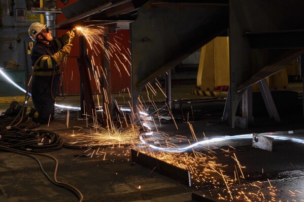 A worker welds a section of the F-111 class frigate's fuselage at a workshop in the Navantia shipyard in Ferrol, northwest Spain, on April 10, 2025. (AP Photo/Bernat Armangue, File)